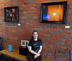 A woman sits on a bench between two abstract photos.
