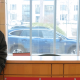 A young man and a young woman pose for a photo in front of a desk with the Denison University logo on it.