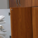 A young woman with curly hair puts folded sheets into a cabinet.